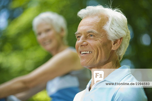 Älterer Mann lächelnd  Frau im Hintergrund  Porträt