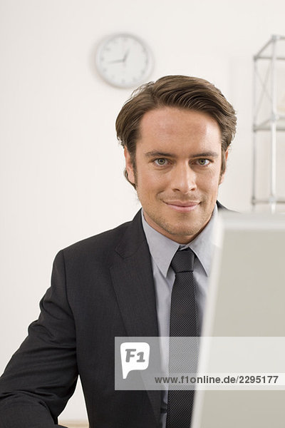 Geschäftsmann am Computer sitzend  Portrait