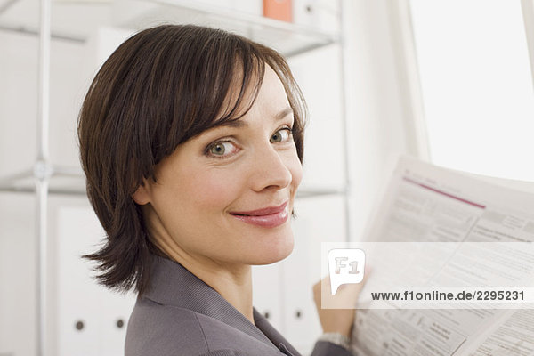 Businesswoman reading newspaper  portrait