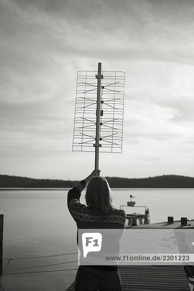 Eine Frau hält ein digitales Fernsehen in den Schären Schweden aerial