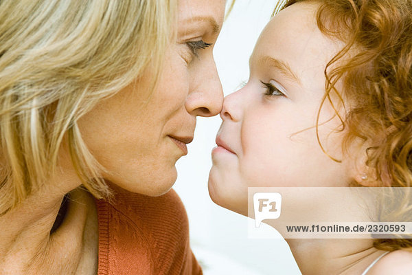Mutter und Tochter berührende Nasen  abgeschnittene Seitenansicht