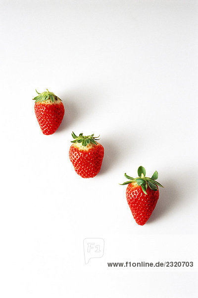 Drei Erdbeeren in einer diagonalen Reihe