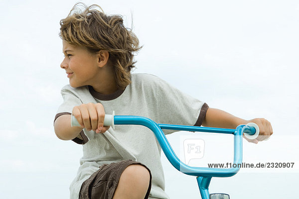 Junge auf dem Fahrrad  Blick über die Schulter  Nahaufnahme