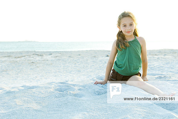 Kleines Mädchen beim Split am Strand  lächelnd vor der Kamera