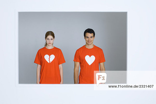 Junges Paar in T-Shirts mit Herzsymbolen  Frauenherz gebrochen