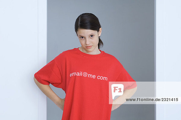 Preteen Mädchen mit T-Shirt bedruckt mit E-Mail-Adresse  Hände auf den Hüften  Blick auf Kamera