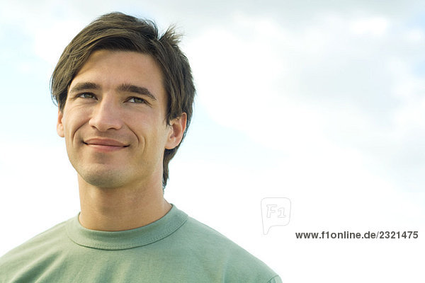 Junger Mann lächelt im Freien  Porträt