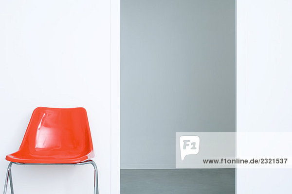 Roter Stuhl gegen graue Wände