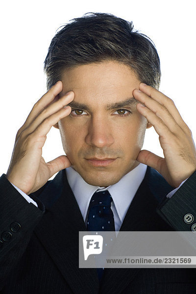Businessman holding head  looking at camera