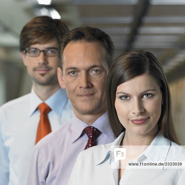 Portrait of businesspeople standing in row and smiling
