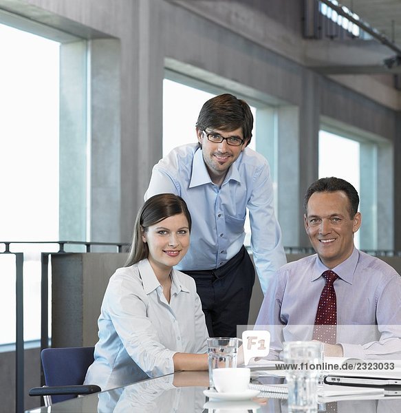 Portrait of three businesspeople smiling in meeting