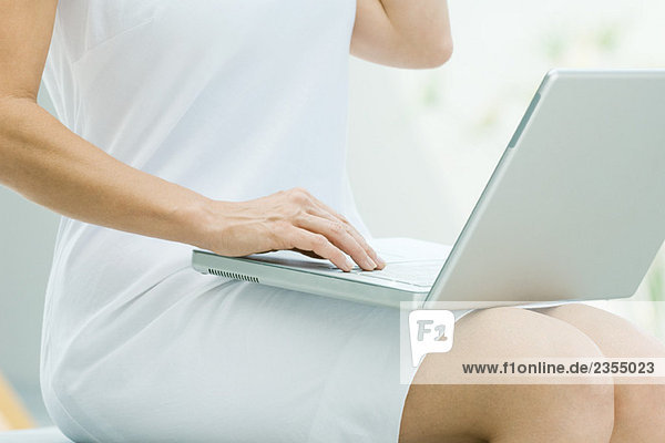 Frau sitzend  mit Laptop-Computer  zugeschnittene Ansicht