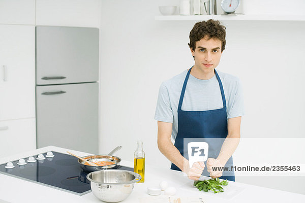 Junger Mann beim Kochen in der Küche