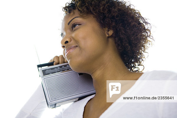 Frau hält Radio auf der Schulter  lächelnd  wegschauend  tiefer Blickwinkel