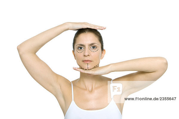 Frau mit plastischen Operationsmarkierungen im Gesicht  Rahmenkopf mit Händen  Blick auf Kamera