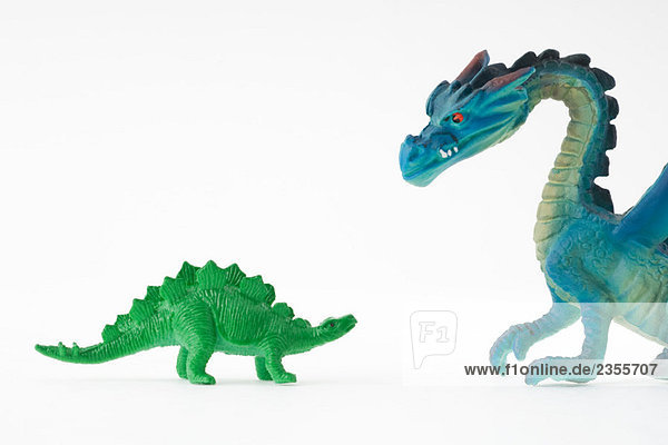 Spielzeug-Dinosaurier vor dem Spielzeug-Drachen
