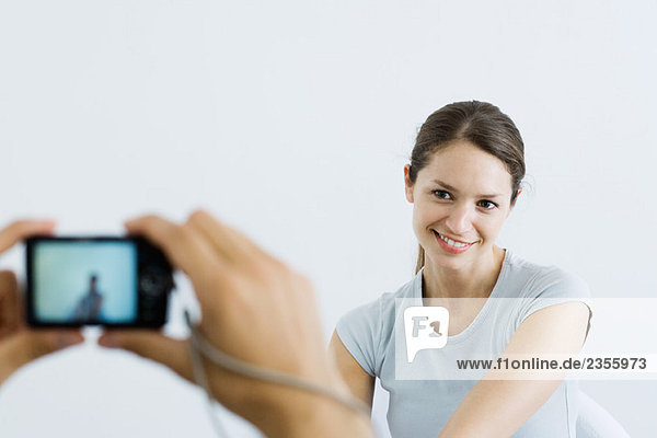 Frau posiert vor der Digitalkamera  lächelnd