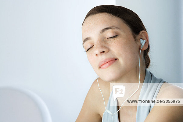 Young woman listening to earphones  eyes closed