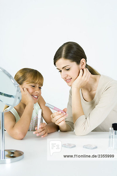 Young woman and preteen sister looking at cosmetics together  both smiling