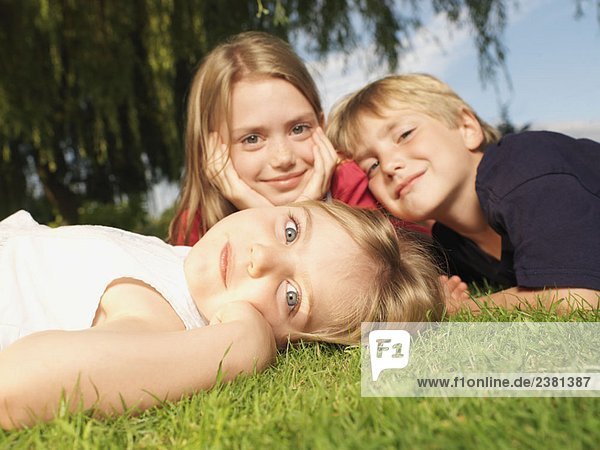 Kleine Kinder auf Gras liegend  Nahaufnahme