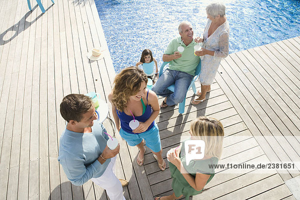 Family on a wooden terrace by a pool