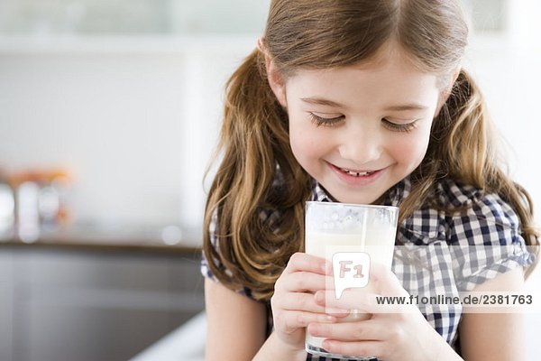 Mädchen beim Blick in ein Glas Milch