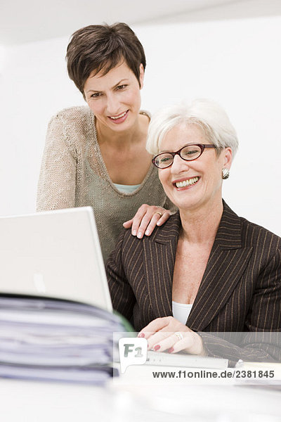 Zwei Frauen arbeiten zusammen an einem PC