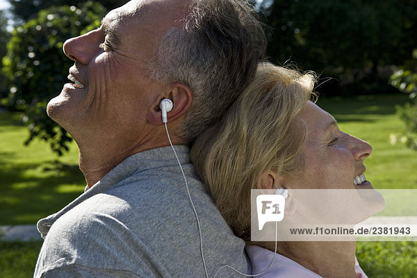 Mann und Frau beim Hören von Kopfhörern