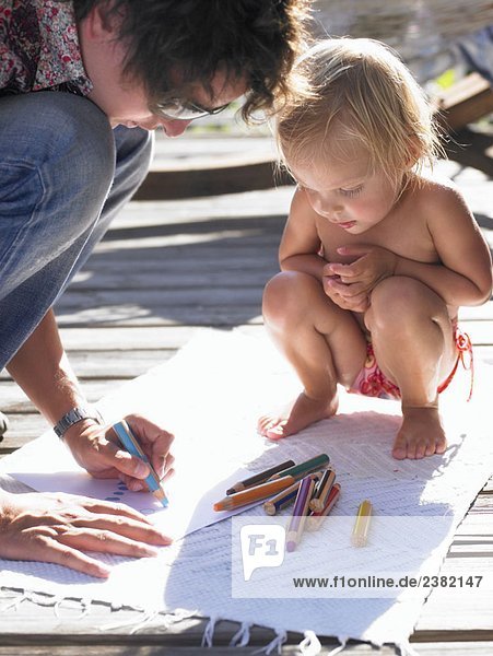 Kleines Mädchen und Mann zeichnen ein Bild