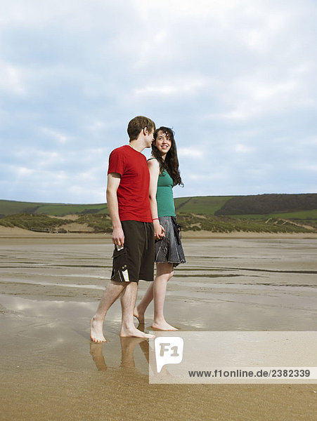 Junges Paar beim Spaziergang am Strand