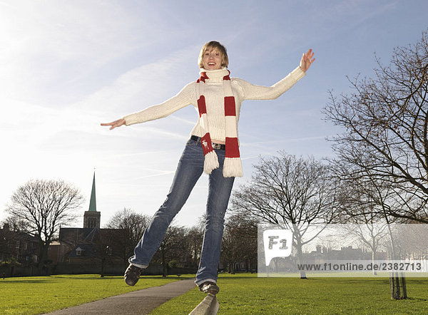 Woman balancing on bench in park