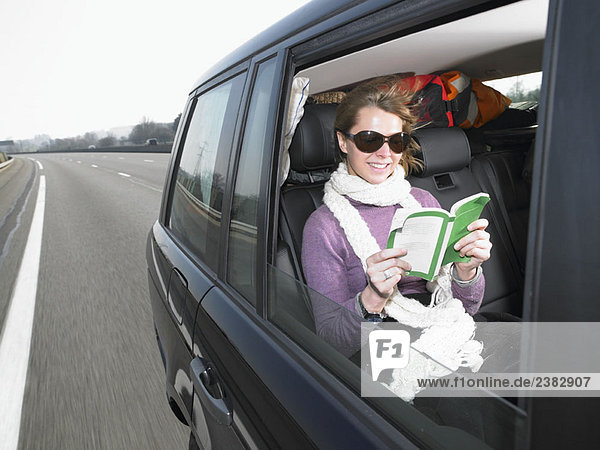 Junge Frau liest im Auto