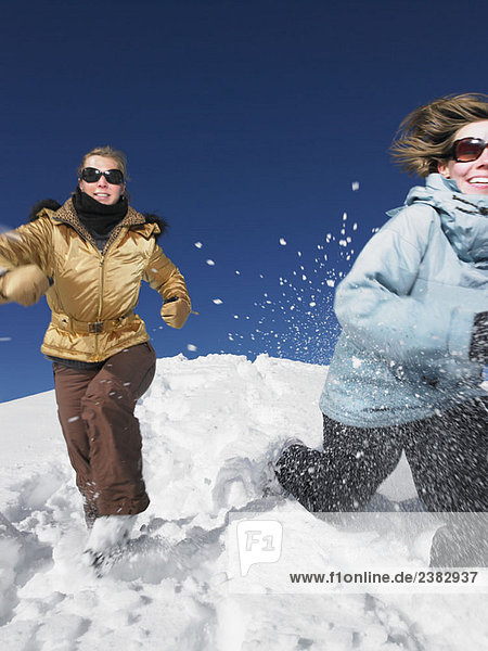 Young women running in snow