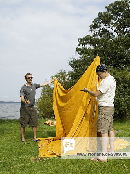Männer mit Problemen beim Aufbau eines Zeltes