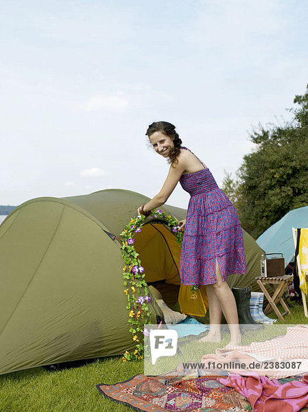 Frau dekoriert ein Zelt mit Blumen