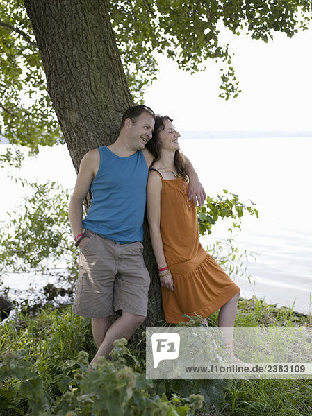 Mann und Frau stehen unter einem Baum