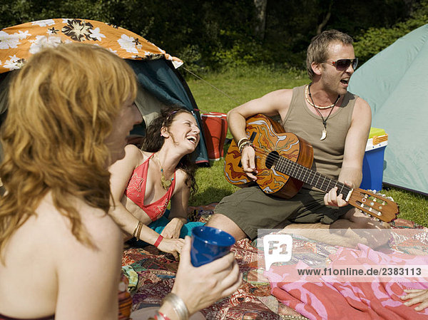 Drei Leute singen zusammen im Camp