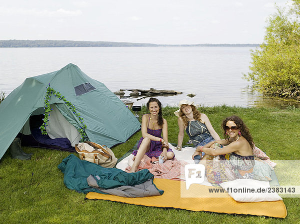 Drei Frauen beim Zelten am Wasser
