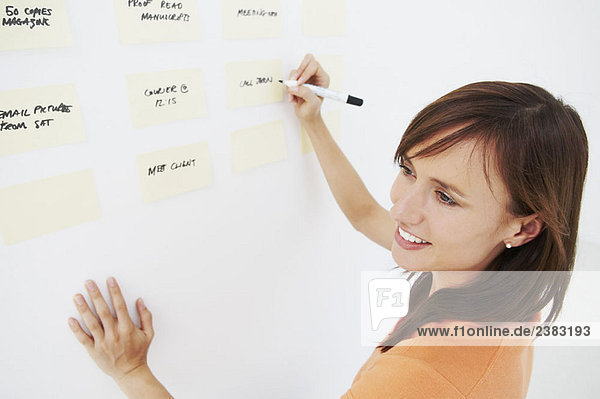 Woman writing notes on wall