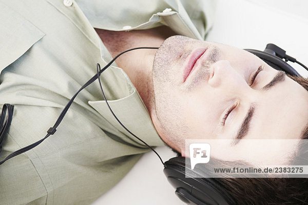 Reclined male relaxes with headphones