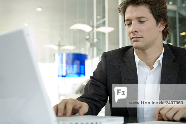 Close-up of a businessman using a laptop in an office