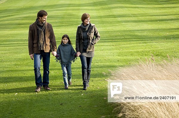 Girl with her parents walking in a park