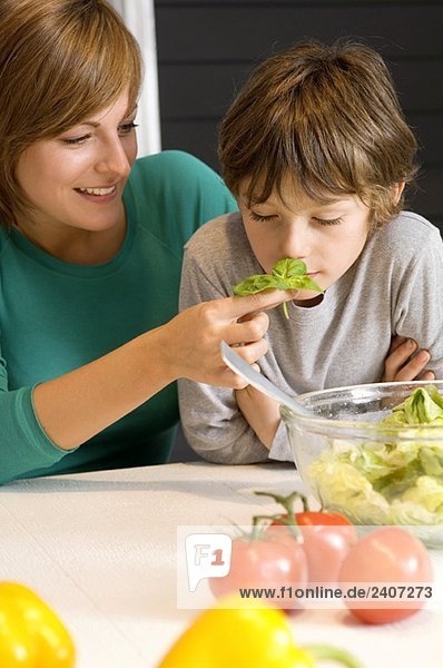 Young woman feeding basil to her son