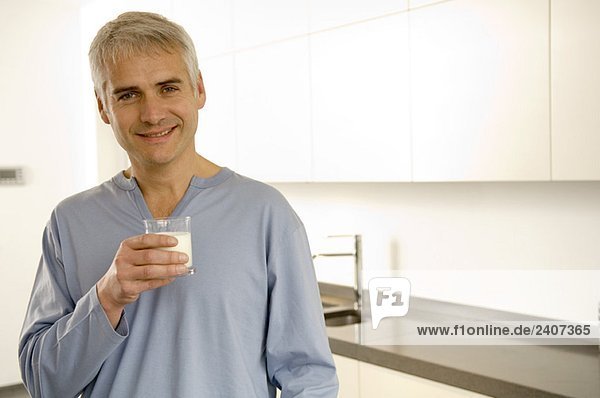 Porträt eines reifen Mannes mit einem Glas Milch