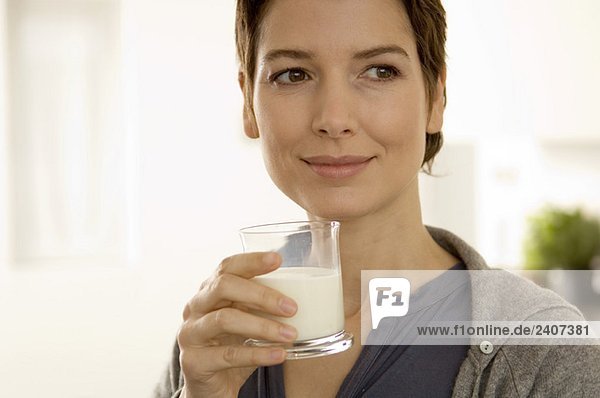 Nahaufnahme einer mittleren erwachsenen Frau mit einem Glas Milch