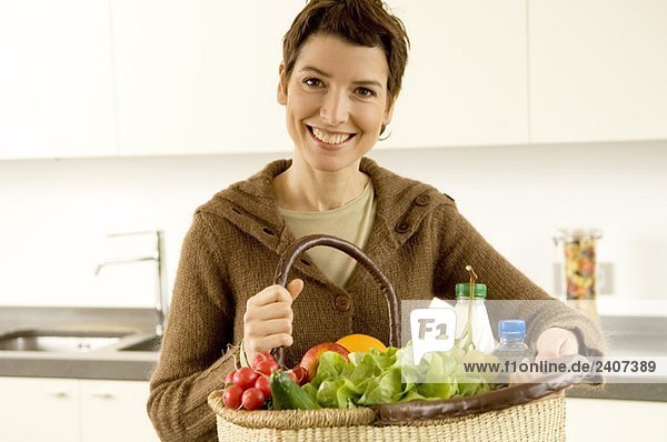 Porträt einer mittleren erwachsenen Frau mit einem Korb mit Obst und Gemüse