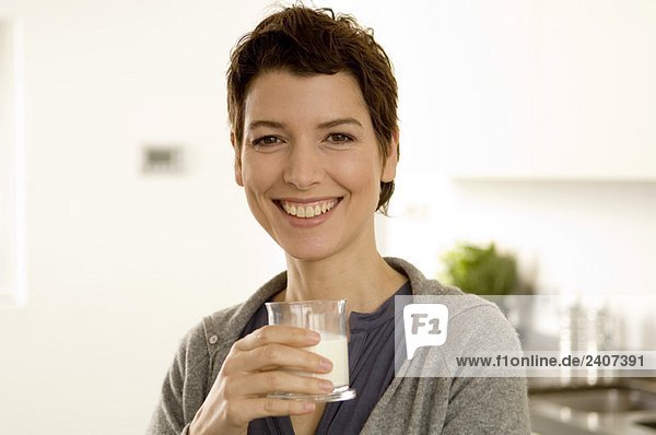Porträt einer mittleren erwachsenen Frau mit einem Glas Milch