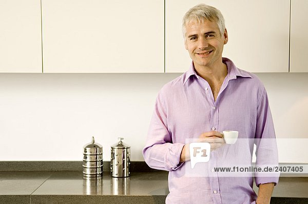 Porträt eines reifen Mannes mit einer Tasse Tee und lächelndem Gesicht