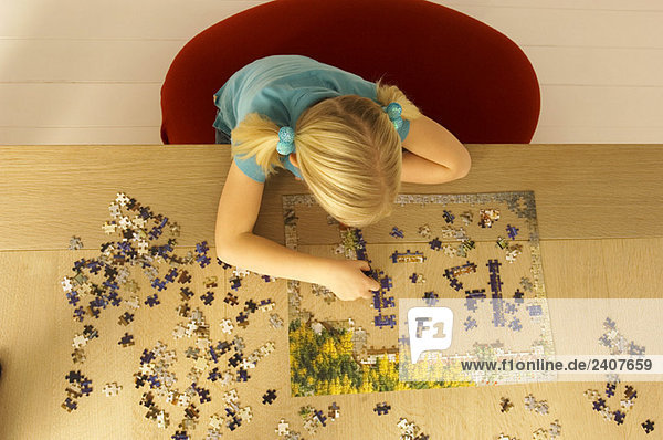 Hochwinkelansicht eines Mädchens beim Puzzlespielen