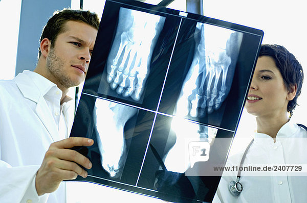 Nahaufnahme von zwei Ärzten bei der Untersuchung eines Röntgenberichtes